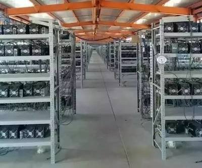 An aerial view of a large-scale mining farm, showcasing rows of mining rigs and cooling infrastructure.